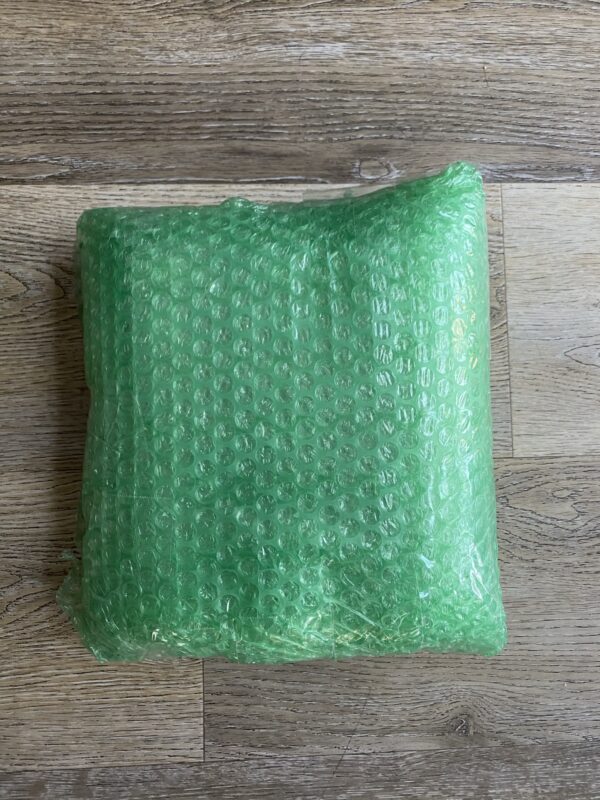 A green bubble wrap on top of a wooden table.