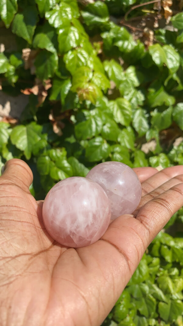 Two pink balls are in a hand