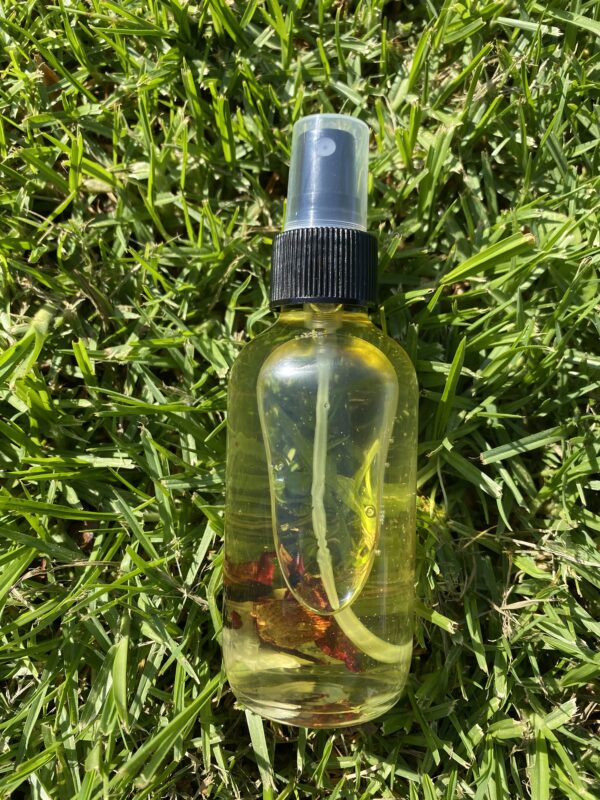 A bottle of oil sitting on top of grass.