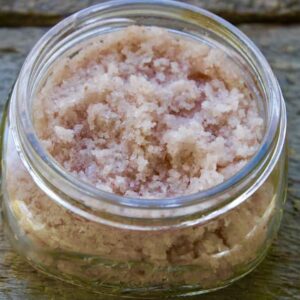 A jar of brown sugar sitting on top of a wooden table.