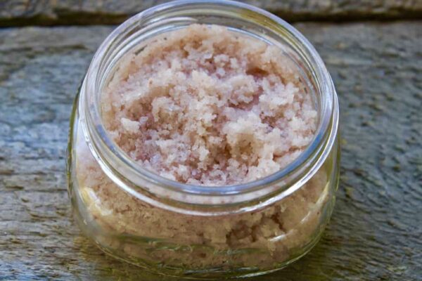 A jar of brown sugar sitting on top of a wooden table.