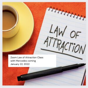 A note that says law of attraction with a cup and pen.