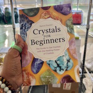 A person holding onto the cover of crystals for beginners