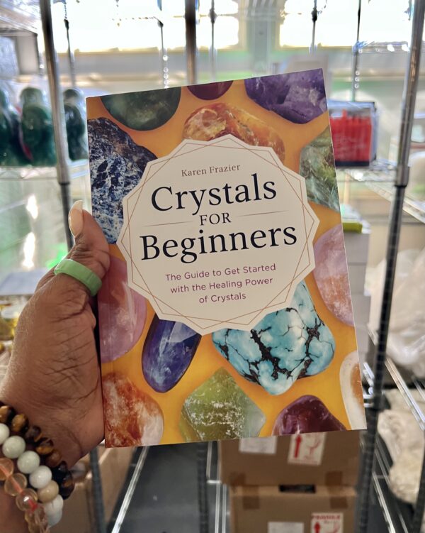 A person holding onto the cover of crystals for beginners