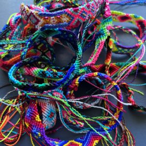 A bunch of colorful bracelets are laying on the ground