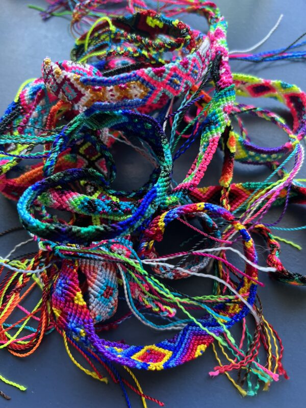 A bunch of colorful bracelets are laying on the ground