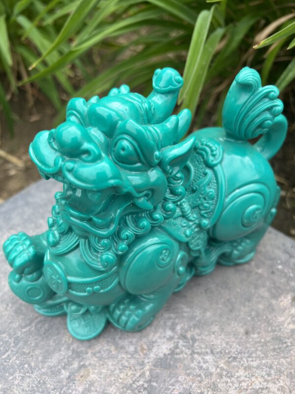 A green statue of a dragon on top of rocks.