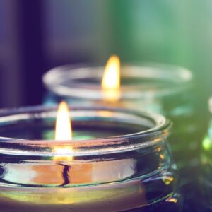 A close up of two candles in a glass holder