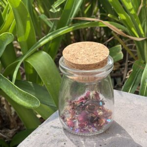 A jar of dried flowers sitting on top of a table.