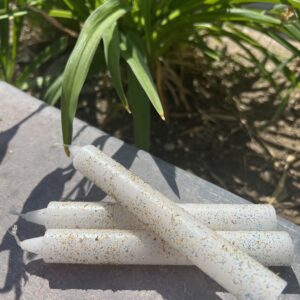 A bunch of white candles sitting on top of a table.