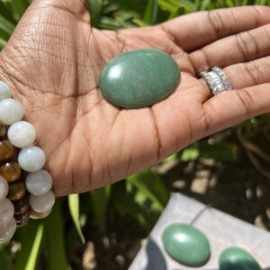 A person holding a green stone in their hand.