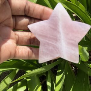 A hand holding a star shaped piece of paper.