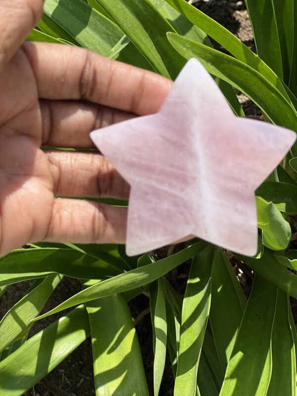 A hand holding a star shaped piece of paper.