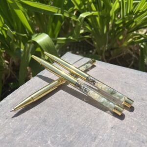 A close up of some green and gold chopsticks