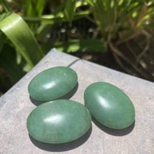 Three green stones sitting on top of a table.