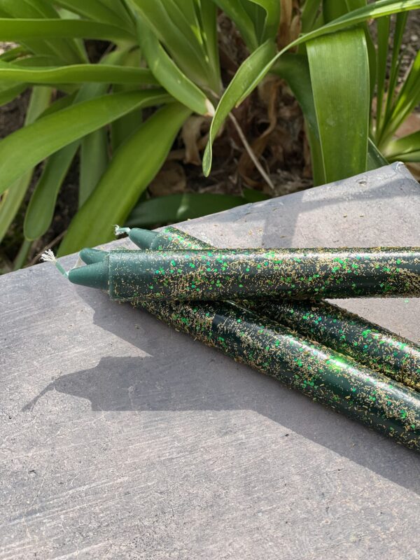 A close up of some green candles on the ground