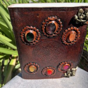 A leather book with some colored stones on it