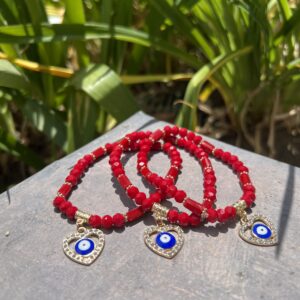 A close up of three bracelets on top of a wooden table.