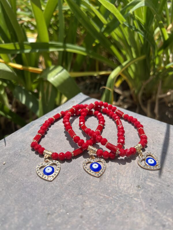 A close up of three bracelets on top of a wooden table.