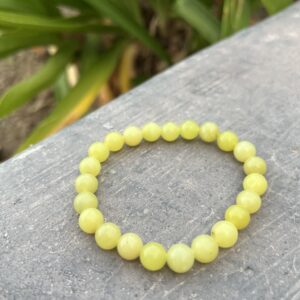 A yellow bracelet is sitting on the ground.