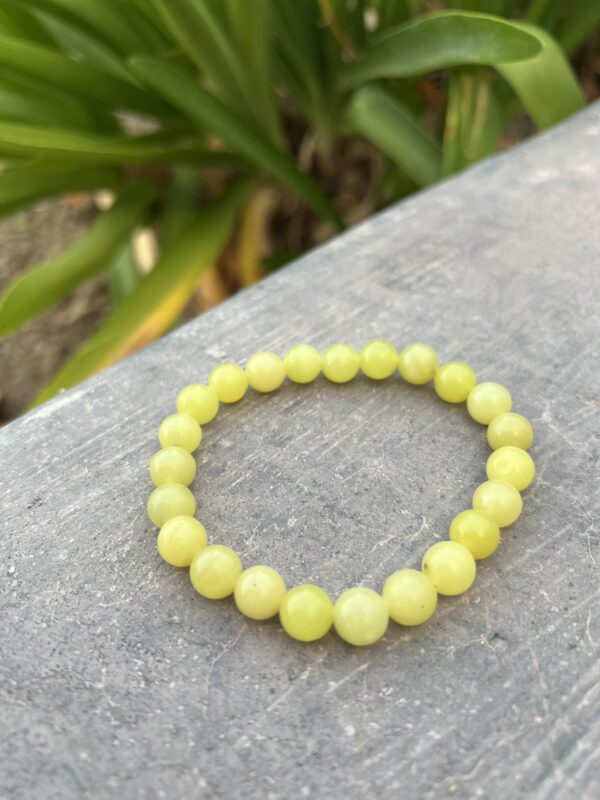 A yellow bracelet is sitting on the ground.