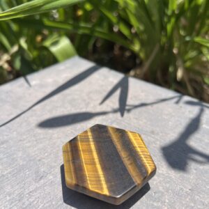 A tiger 's eye stone is sitting on the ground.