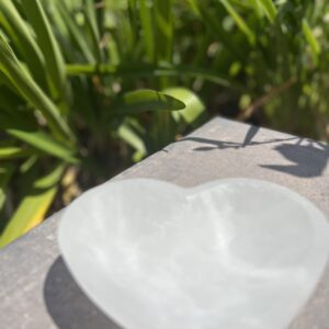 A white heart shaped bowl sitting on top of a table.