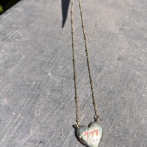 A heart shaped necklace with the word " mom " written on it.