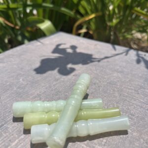 A group of green sticks sitting on top of a wooden table.