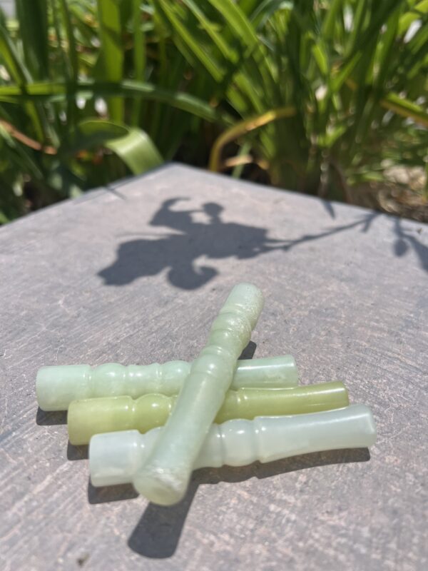 A group of green sticks sitting on top of a wooden table.