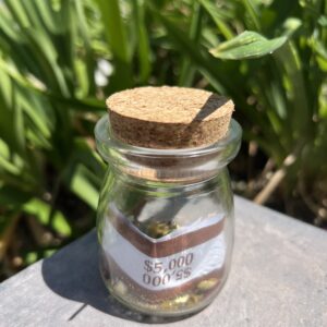 A jar with a cork lid sitting on top of a table.