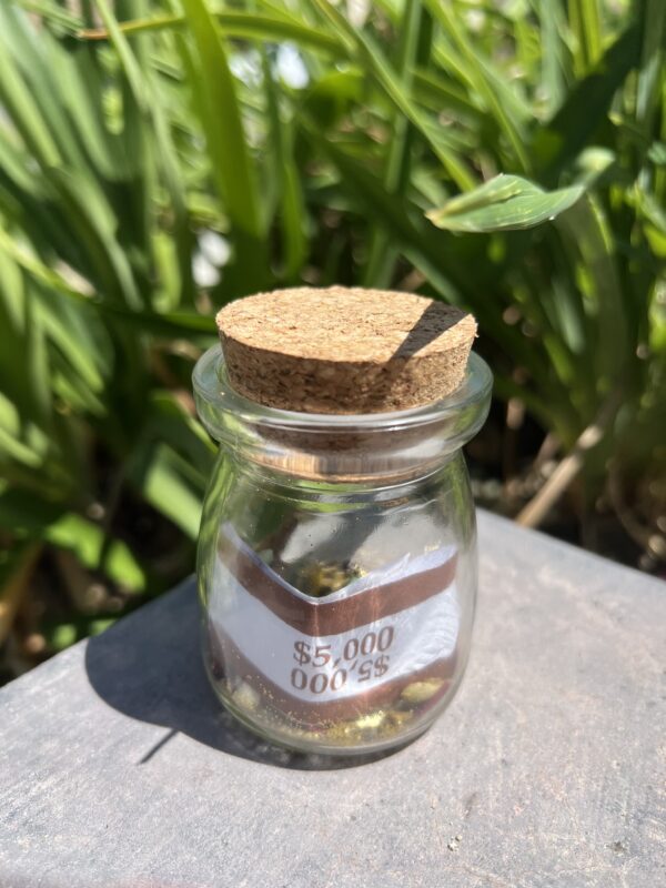 A jar with a cork lid sitting on top of a table.