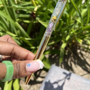 A person holding a glass tube with a bee on it.