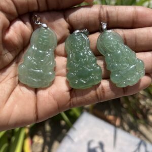 A person holding three green jade pendants in their hands.