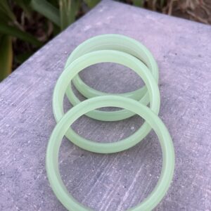 A set of four green plastic bracelets sitting on top of a table.