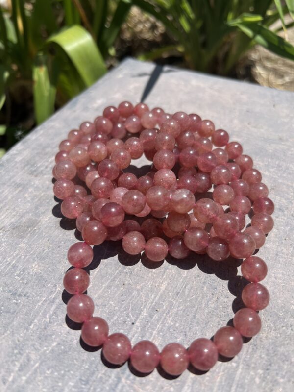 A stack of pink beads sitting on top of a table.