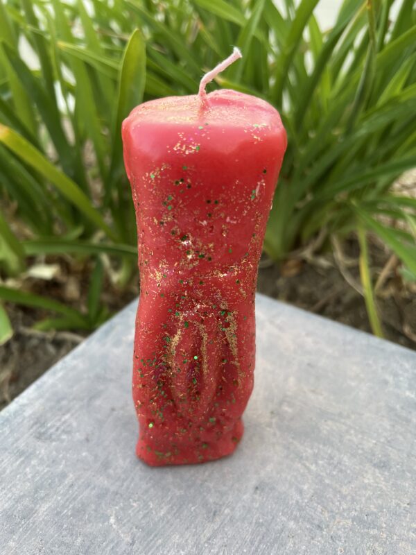 A red candle sitting on top of a table.