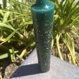 A green candle sitting on top of a table.