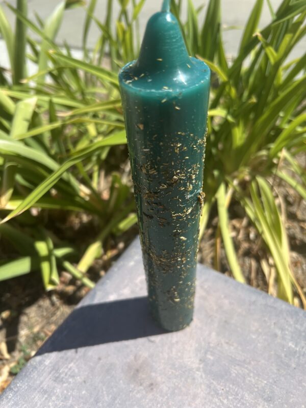 A green candle sitting on top of a table.