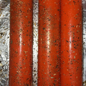 Three red candles are on a foil wrapper.