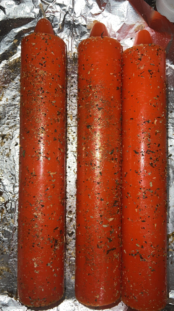 Three red candles are on a foil wrapper.