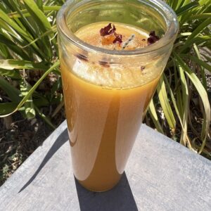 A glass of orange juice sitting on top of a table.