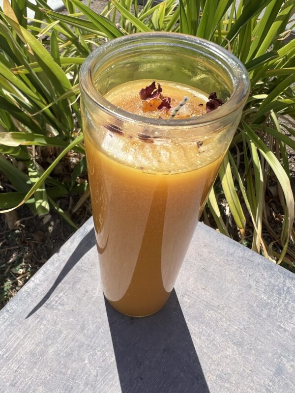 A glass of orange juice sitting on top of a table.