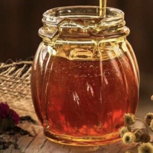 A jar of honey sitting on top of a table.