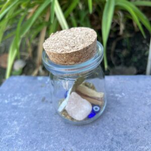 A glass jar with some rocks and other items inside of it