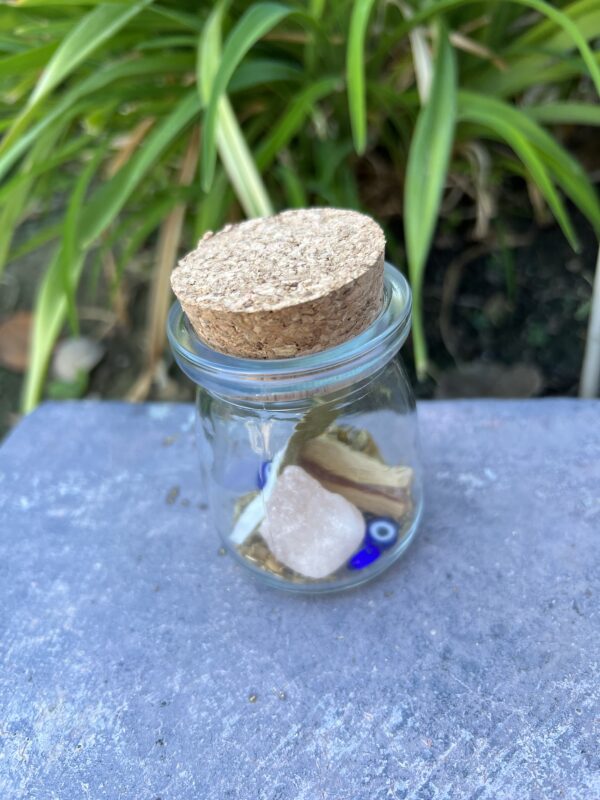 A glass jar with some rocks and other items inside of it