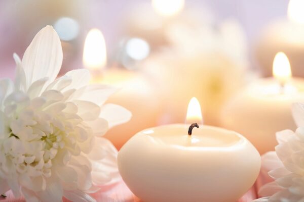 A candle and some flowers on a table