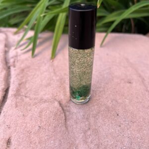 A bottle of green liquid sitting on top of a stone surface.