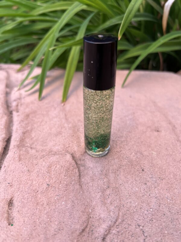 A bottle of green liquid sitting on top of a stone surface.