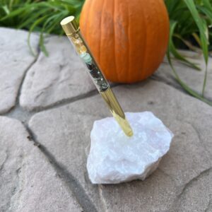 A knife on top of a rock near an orange pumpkin.